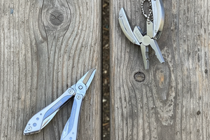 Two multi-tools on a wooden surface